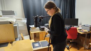 Hanketyöntekijä Anni Ilves ottaa valokuvaa lasinegatiivista.