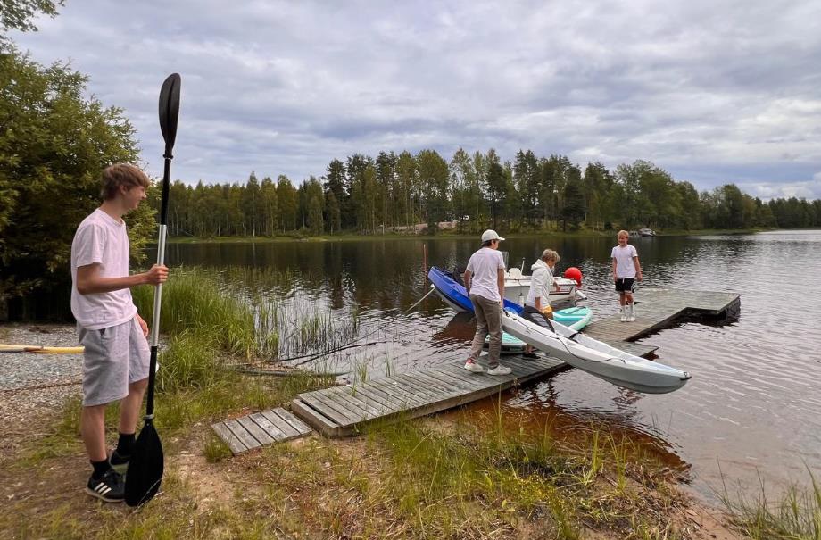 Nuoria laiturilla kajakin kanssa