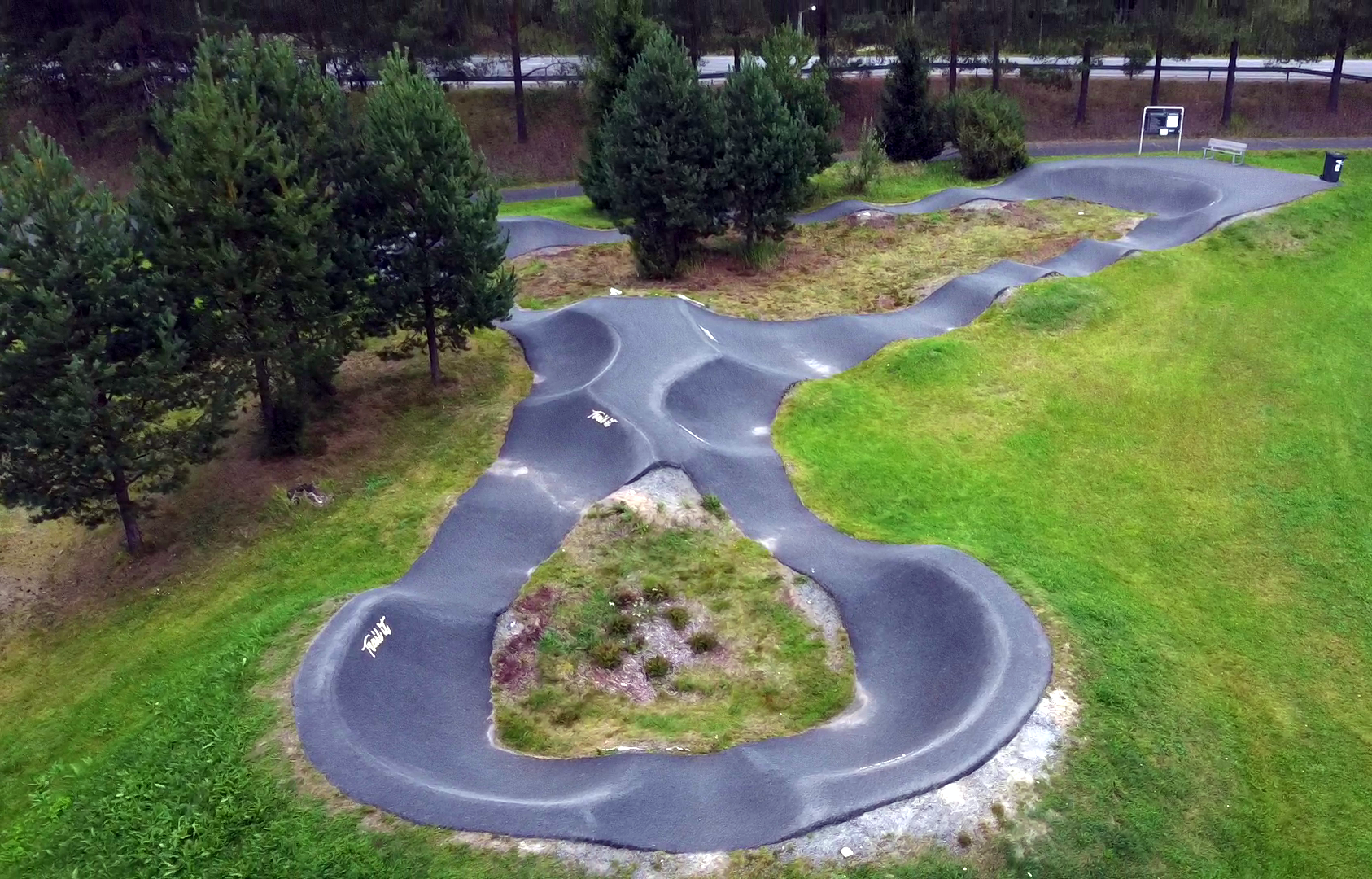 Ilmakuva Petäjäveden pumptrack-radasta. Rata kulkee osin puiden ympärillä.