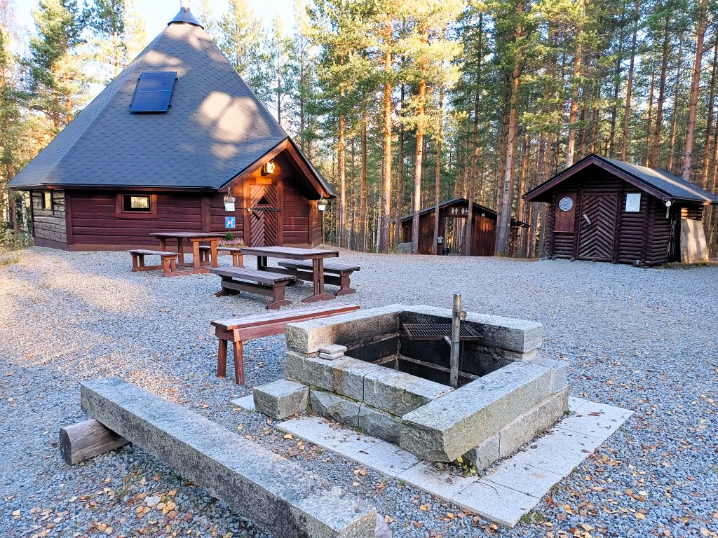 Nuotiopaikka ja taustalla kota.