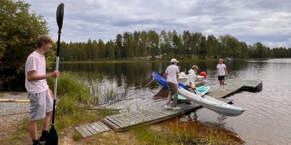 Nuoria laiturilla kajakin kanssa