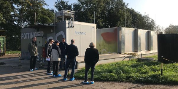 Ihmisiä biokaasulaitoksen vierellä