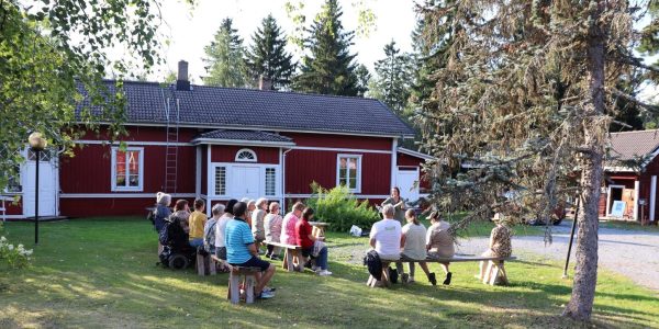 Kuvassa ihmisiä yhteislaulutilaisuudessa Vinnin pihalla